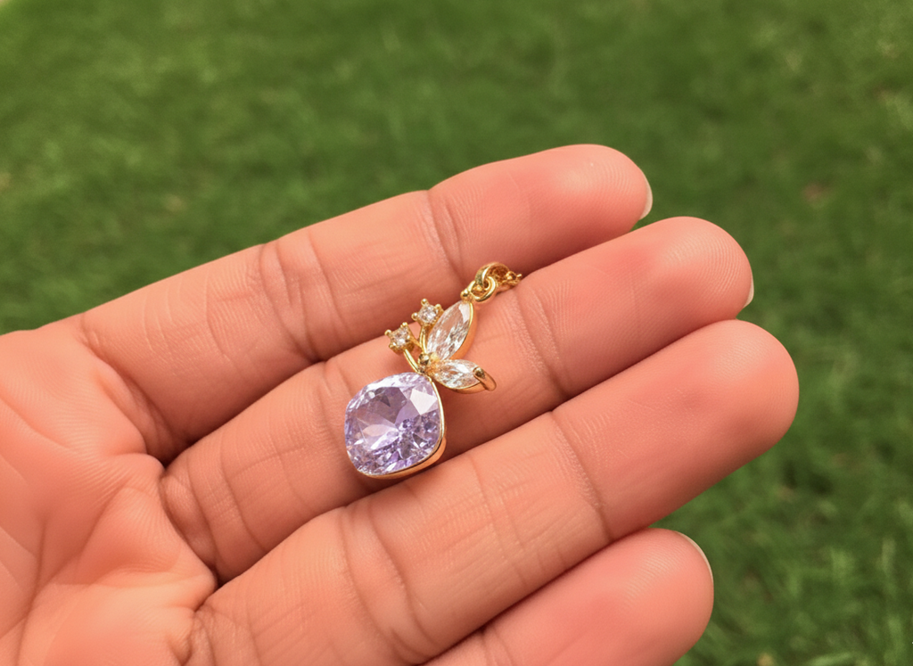A gold plated necklace with a cherry charm