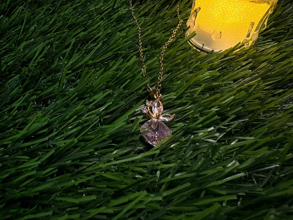 A gold plated necklace with a cherry charm