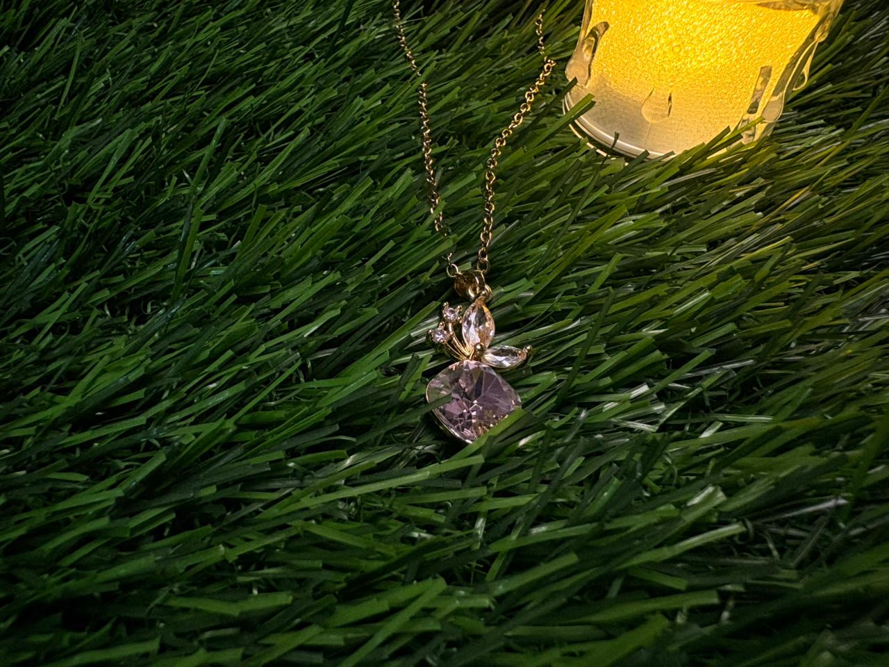 A gold plated necklace with a cherry charm