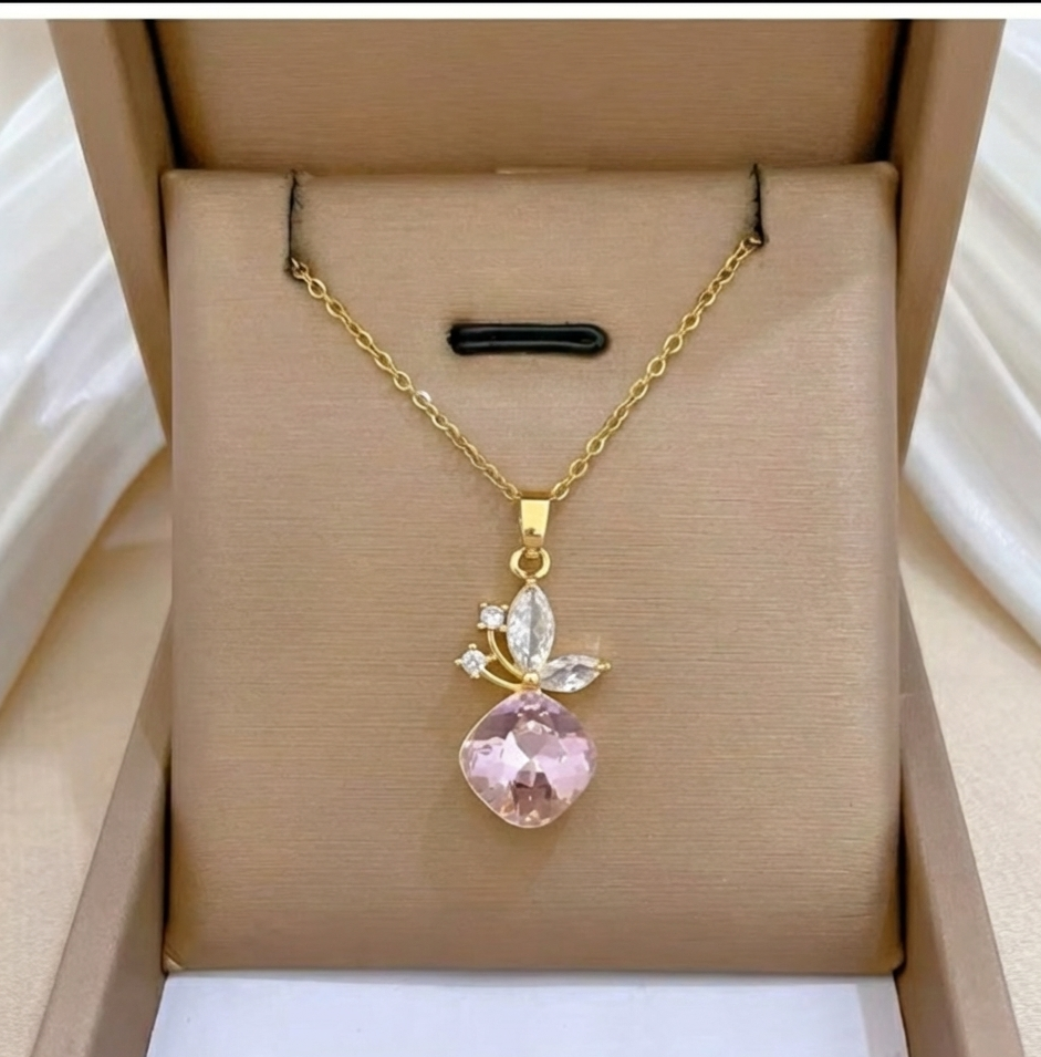 A gold plated necklace with a cherry charm